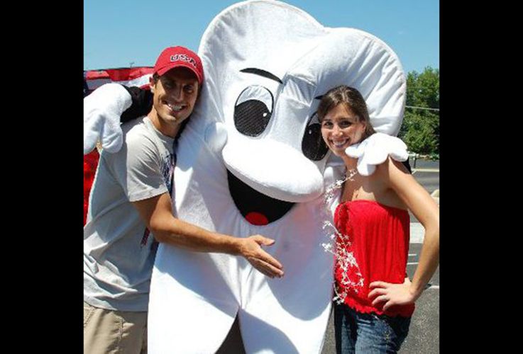 Drs. Katie and Aaron Carroll smiling with tooth mascot