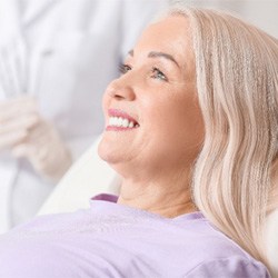Woman smiling in the dentist’s chair with dental implants  