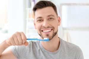 Man brushing his teeth with tips from dentist in Groveport