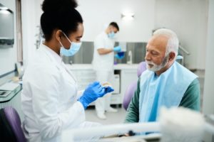 dentist talking to mature man about dentures 