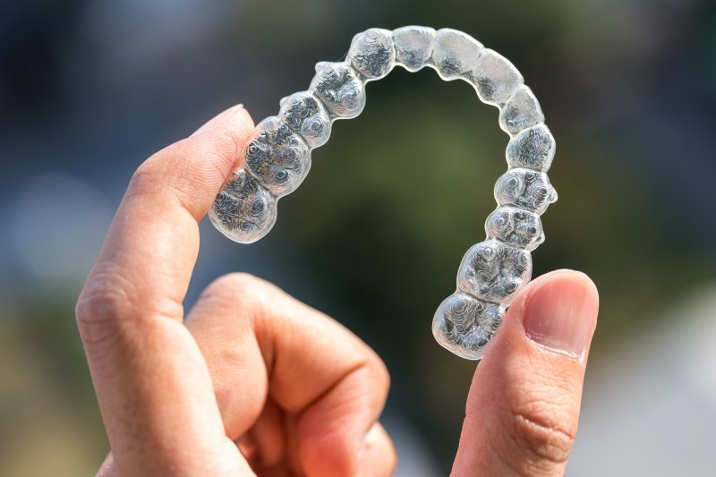 A hand holding an Invisalign aligner